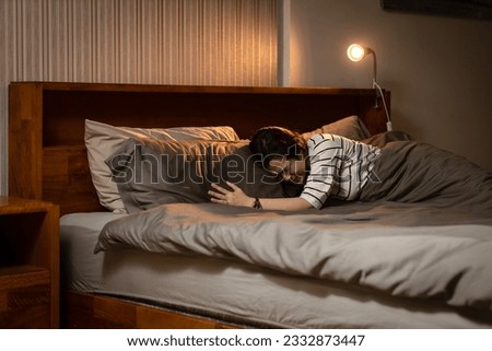 Middle aged woman crying in bed at home,coping with loss,guilt and self-blame after a loss,moments of intense sadness and despair,Depression,emotional and psychological stress,grief and bereavement Royalty-Free Stock Photo #2332873447