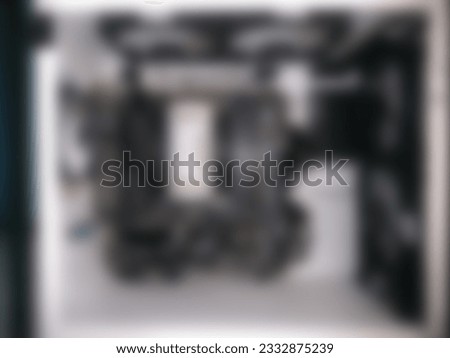 Blurred defocused photo of White PC gaming setup showcasing black components, for background template. Out of focus, noise, over or under exposure, over compressed effect.