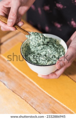 Preparing ravioli with ricotta cheese and spinach. Fresh homemade pasta. Traditional Italian food. Royalty-Free Stock Photo #2332886945