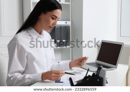 Human resources manager reading applicant's resume in office