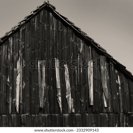 a damaged shield of a barn repaired by light boards