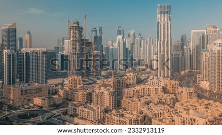 Dubai's business bay towers aerial morning. Rooftop view of some skyscrapers and new buildings under construction during sunrise