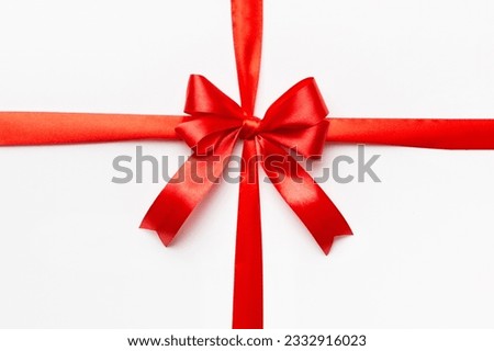 Top view of Red ribbon rolled and red bow isolated on colored background. Flat lay with copy space. Royalty-Free Stock Photo #2332916023