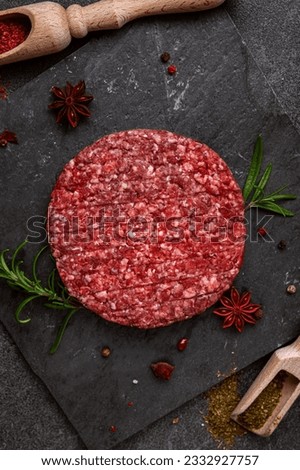 Juicy raw burger patty against a dark backdrop. Creation is perfect for burger lovers seeking an authentic and flavorful experience Royalty-Free Stock Photo #2332927757