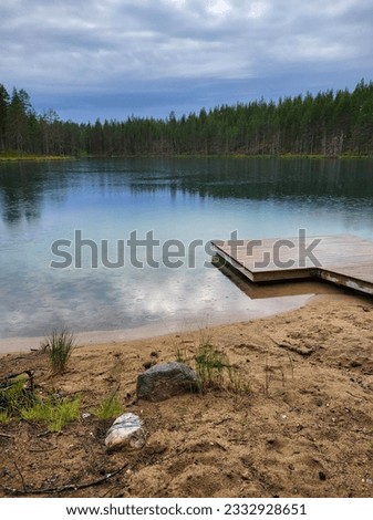 A beautiful small pond and pier on a cloudly and rainy day in Taivalkoski camping area