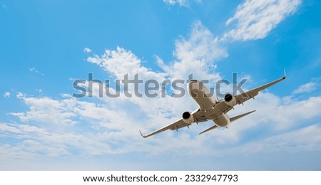 White passenger airplane flying in the sky amazing clouds in the background - Travel by air transport Royalty-Free Stock Photo #2332947793