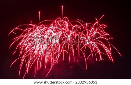 a photography of a fireworks display with red and white lights, fireworks in the sky with red and white lights.