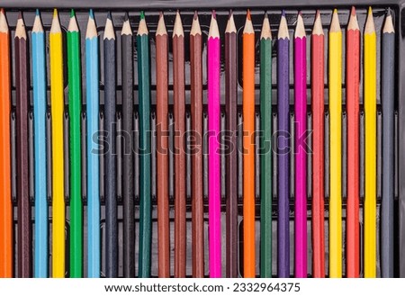 Black background with lots of colorful pencils. School supplies are laid out on a black background - top view. Back to school.
