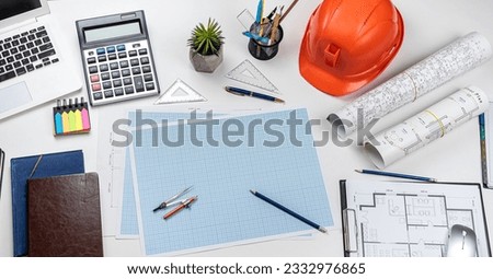 Orange safety helmet with architectural plan blueprint  and tools on office table. Top view. Industry concept