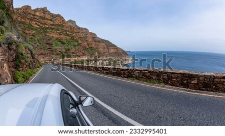 Driving on narrow road pass overlooking scenic Atlantic ocean sea water  mountain landscape on Chapmans Peak Drive route Cape Town.