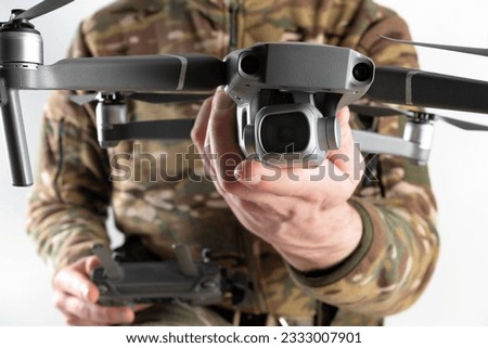 Concept of using drones in modern warfare. Close-up of a drone in hands of a soldier on white background. Military use of drones