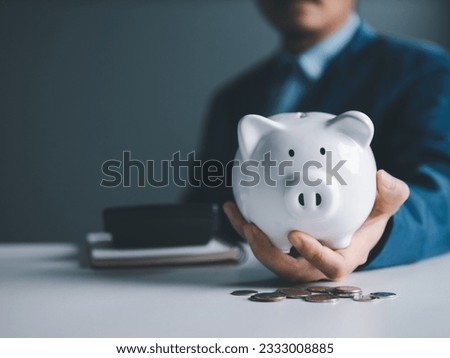 Money Saving Strategies. Businessman sit on chair and piggy bank, coins and calculator are on table. Unlocking Financial Success through Smart Investments, Banking, and Savings.