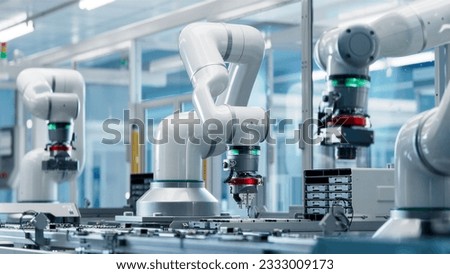 Advanced High Precision Robot Arm inside Bright Electronics Factory. Electronic Devices Production Industry. Component Installation on Circuit Board. Fully Automated Modern PCB Assembly Line. Royalty-Free Stock Photo #2333009173