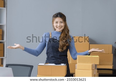 Happy asian businesswoman owner checking orders from customers with laptop sitting at desk in home office, sell products online concept.