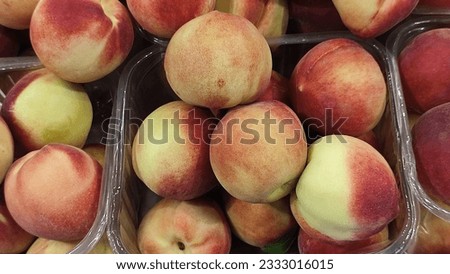 fresh peaches fruits, food in the grocery store, red-yellow background. High quality photo Royalty-Free Stock Photo #2333016015