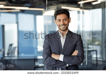 Portrait of successful mature boss, senior businessman in business suit looking at camera and smiling, man with crossed arms working inside modern office building Royalty-Free Stock Photo #2333021699