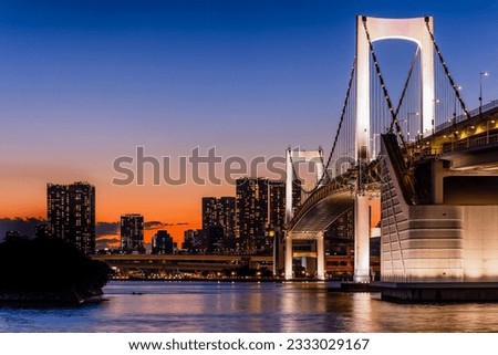 Beautiful sunset colors and city lights of Tokyo and the Rainbow Bridge in Tokyo Bay
