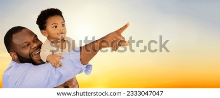 African american father holding little son pointing and watching beautiful sunset sky landscape of amazing nature : Education concept, father teaching son.