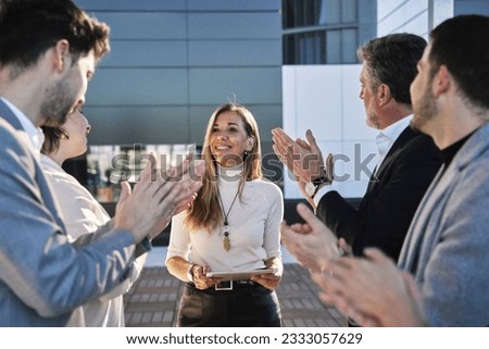 group of businessmen at a meeting or business plan exhibition applauding a middle-aged woman who was the event's sponsor Royalty-Free Stock Photo #2333057629