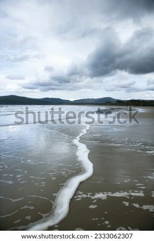 Ocean with distant mountains and cloudy sky in Daintree Rainforest, Australia.