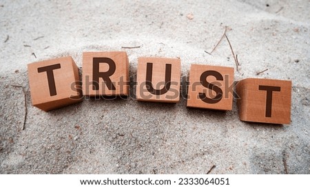 Trust symbol in wooden cubes. Sand background. Business and Trust Concept.
