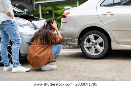 Asian women driver check for damage after a car accident before taking pictures and sending insurance. Online car accident insurance claim after submitting photos and evidence to an insurance company.