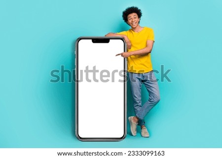 Full body length image of young promoter guy new smartphone app website point finger electronic panel advert isolated on aquamarine color background