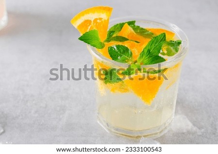Refreshing Cold Cocktail or Mocktail with Orange, Orange Lemonade on Bright Background