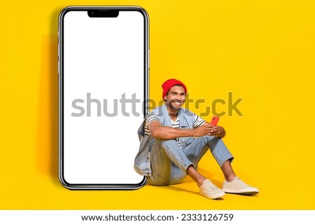 Full length photo of good mood man wear jeans outfit communicating device empty space isolated yellow color background