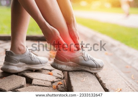 female joggers pain and discomfort after running in the public park. care and treatment for ankle injuries concept. Royalty-Free Stock Photo #2333132647