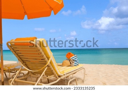 sunbeds with beach accessories and umbrella at picture perfect caribbean beach