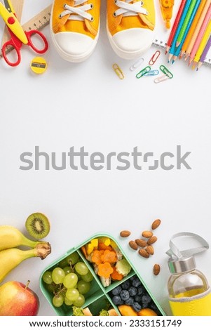 Break snack during educational process concept. Top view vertical picture of sneakers, lunch box and school supplies on white isolated backdrop with copy-space for text or advert