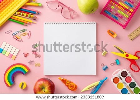 Primary school art studio idea. Top view shot of range of vivid art supplies, drawing pad, paints, eyeglasses, plasticine, abacus and more on pastel pink background with blank space for ad or picture