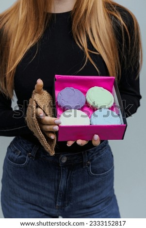 The girl is holding a box with handmade soap in her hands