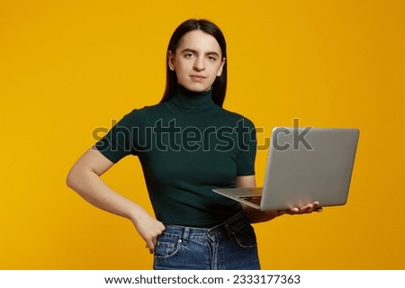 Photo of serious calm woman hold use netbook wear green t-shirt isolated on yellow color background
