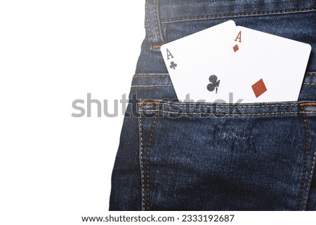 Pair of aces cards inside pocket of navy blue jeans.