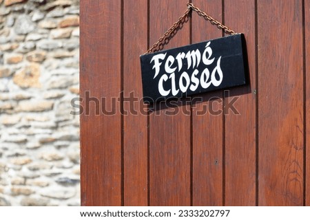Information board on door with French and English word: closed