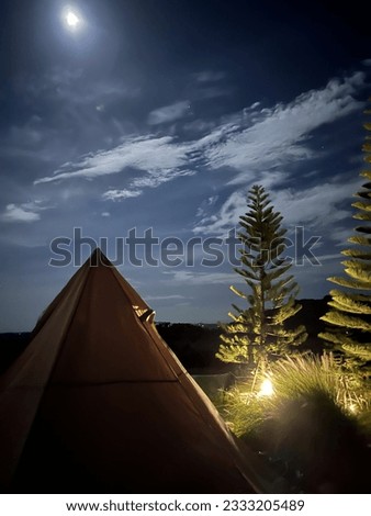 A triangular tent with a chilling night sky
