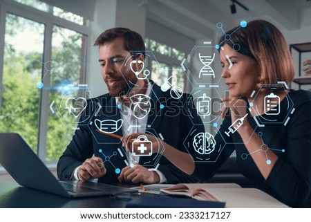 Thoughtful businesspeople typing on laptop at office workplace. Concept of team work, business education, internet surfing, brainstorm, project information technology. Medical healthcare hologram Royalty-Free Stock Photo #2333217127