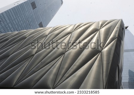 A photo of a metal exterior building called 'The Shed' in New York City and another glass building in the background. 