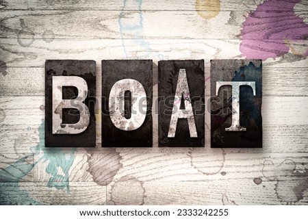 The word -BOAT- written in vintage dirty metal letterpress type on a whitewashed wooden background with ink and paint stains.