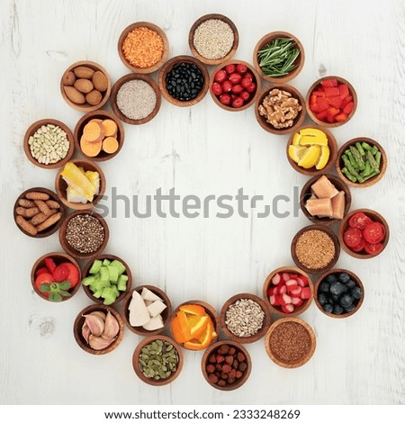 Healthy super food selection in wooden bowls forming a wheel over distressed whte wood background. High in antioxidants, vitamins, minerals and anthocyanins.