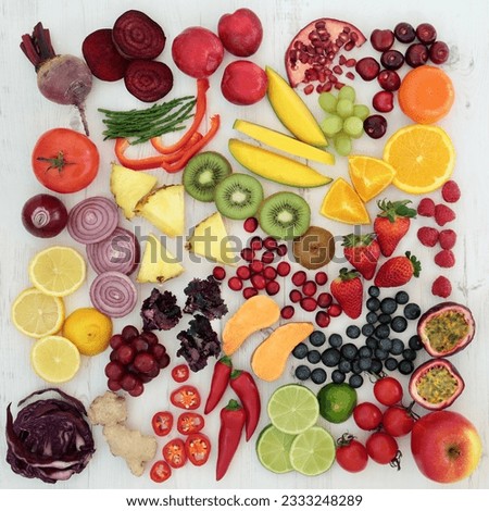 Healthy fresh fruit and vegetable superfood on distressed white wood background, high in antioxidants, anthocyanins, vitamins, dietary fiber and minerals.
