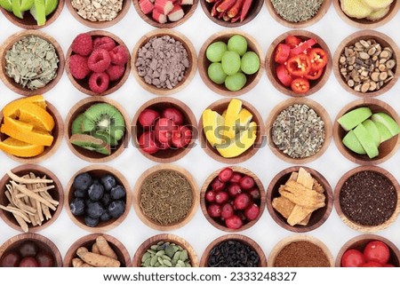Food selection for cold and flu remedy to boost immune system, high in vitamins, anthocyanins, antioxidants and minerals in wooden bowls over white background.