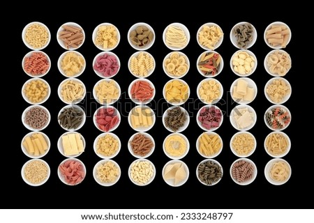 Large dried pasta spaghetti collection in round porcelain bowls over black background.