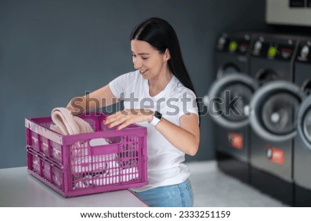 Woman in the public room to wash her cloths, self service commercial laundry and drying machine in a public room. Royalty-Free Stock Photo #2333251159