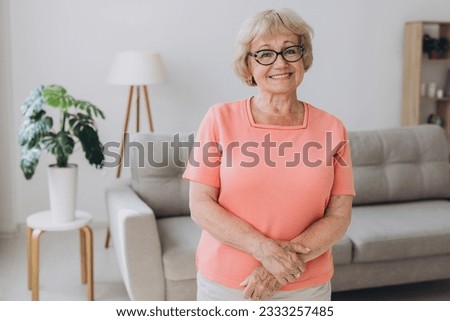 Comfort relaxed senior old elderly woman grandmother at home looking at camera in the living room. Pension concept.