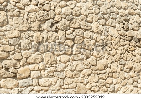 beige stone background texture of a wall on a sunny day with copy space