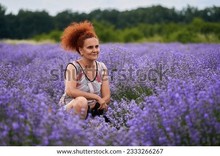 Woman nature photographer with her camer in a  lavender field shooting pictures