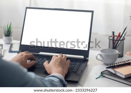 man's hands working on laptop in front of white
